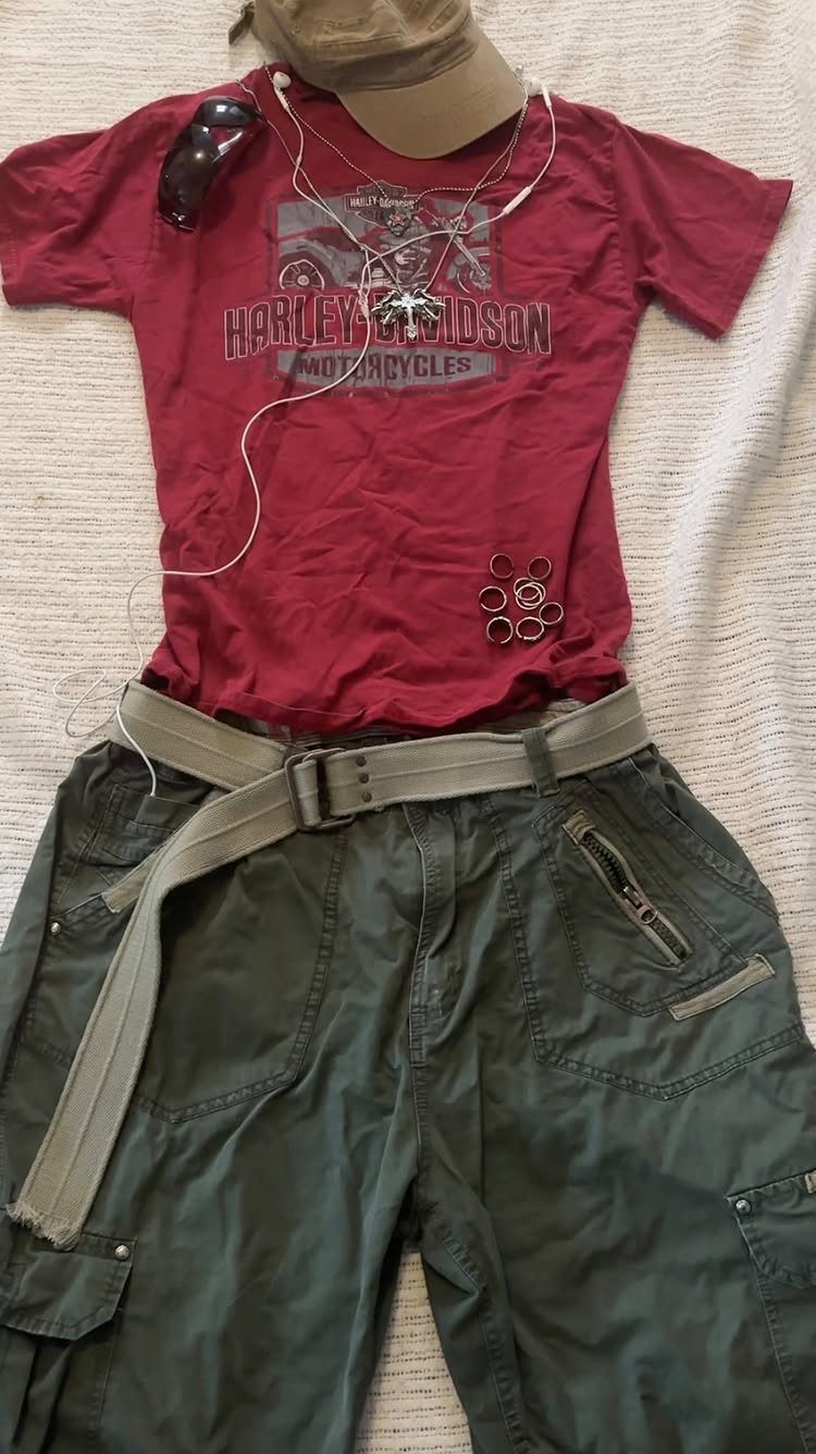 Red graphic t-shirt and olive green cargo shorts laid out with accessories on white fabric.