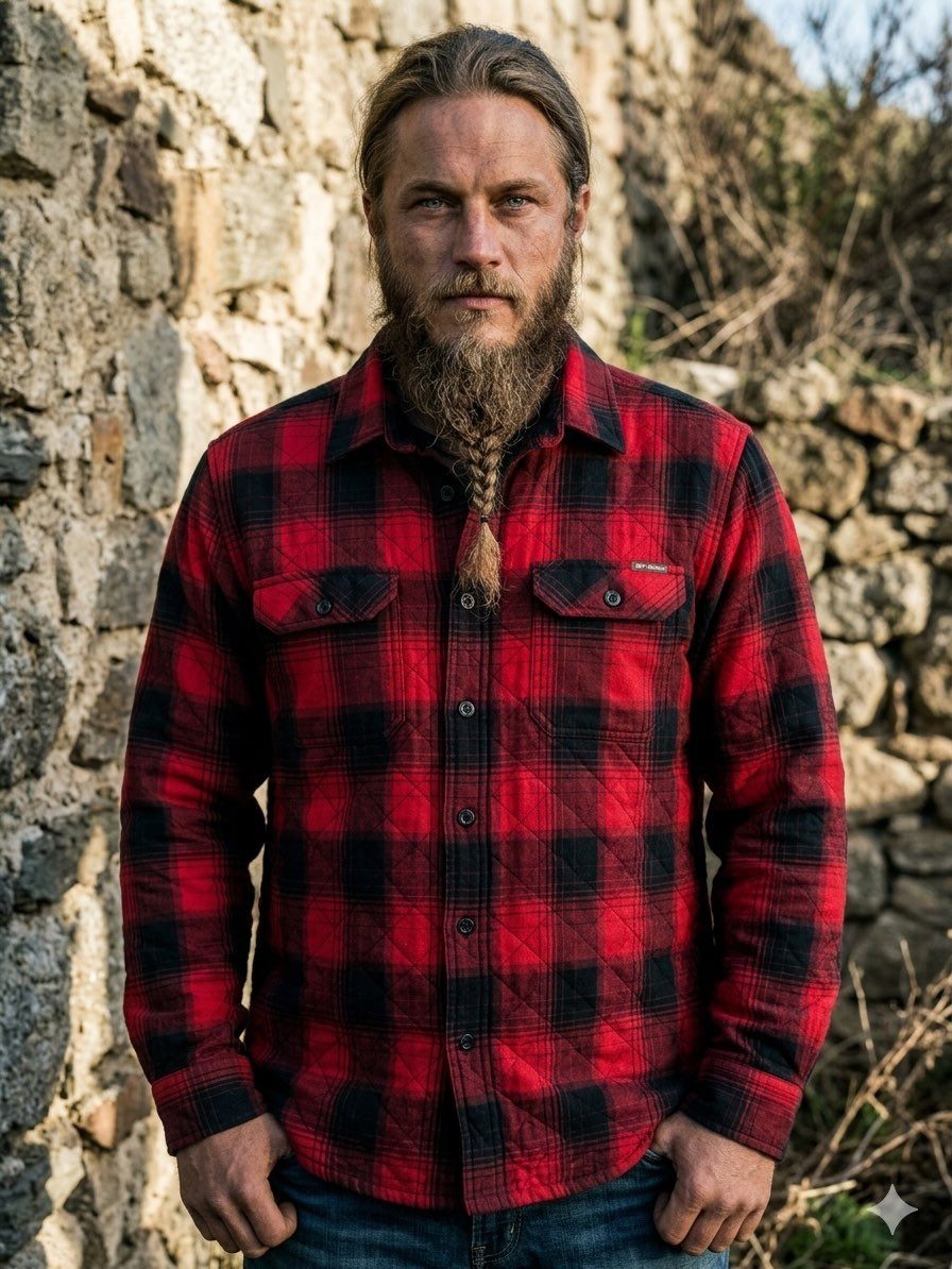 Man with a long braided beard wearing a red and black plaid flannel shirt jacket.