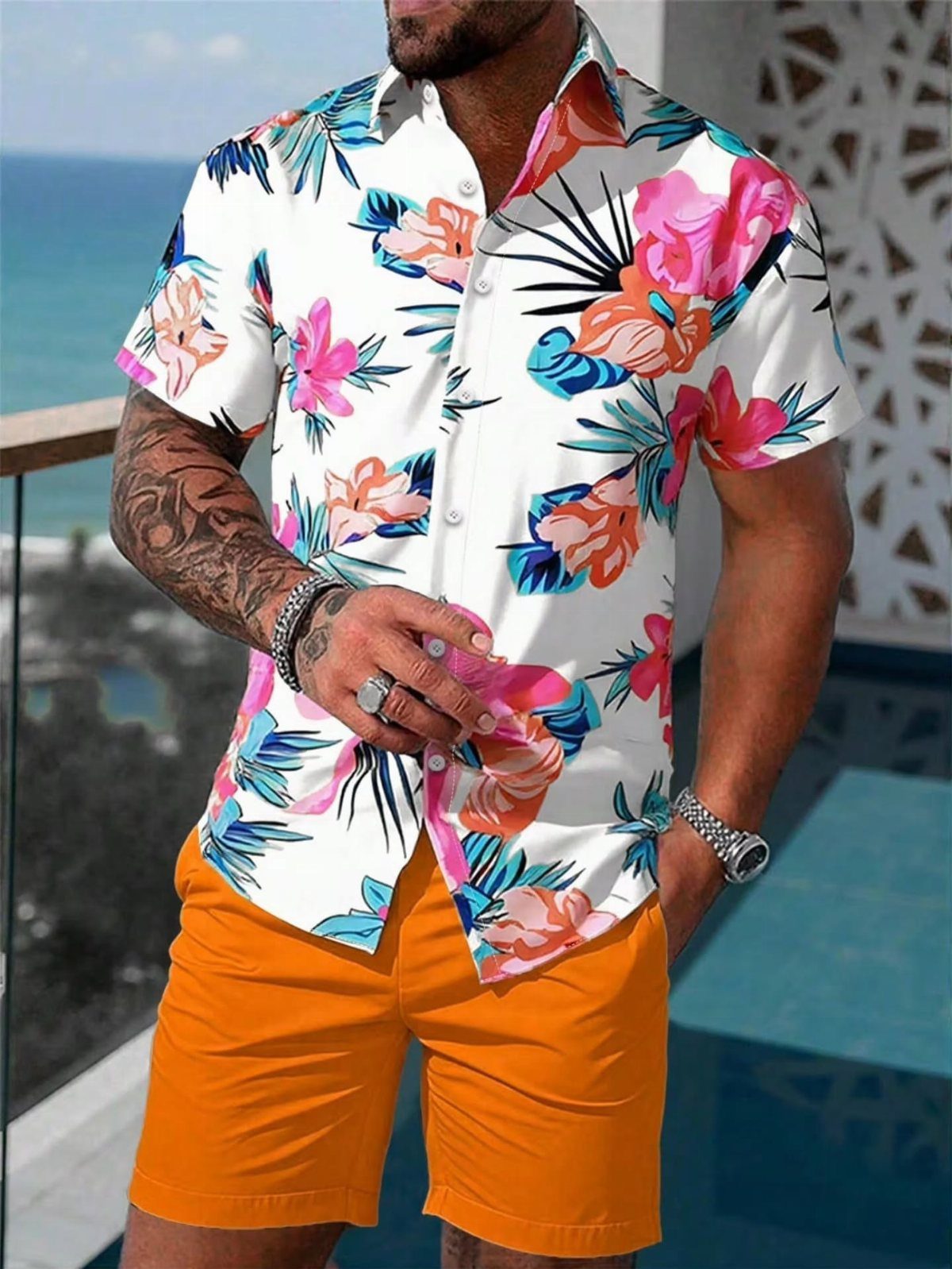 Man wearing a white tropical floral print shirt and bright orange shorts outdoors.