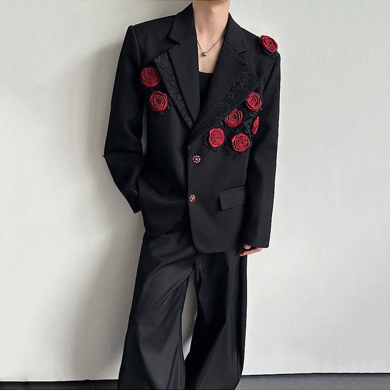 A person wearing a black suit decorated with large red rose floral appliqués.