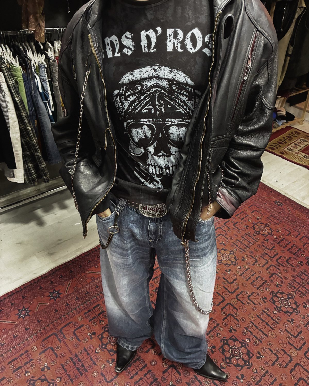 Man wearing a black Guns N' Roses skull graphic t-shirt and a leather jacket.