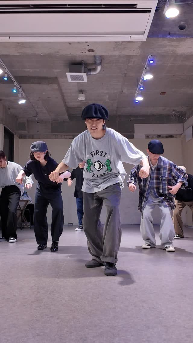 Dancers in baggy streetwear performing a hip hop dance routine in a studio.