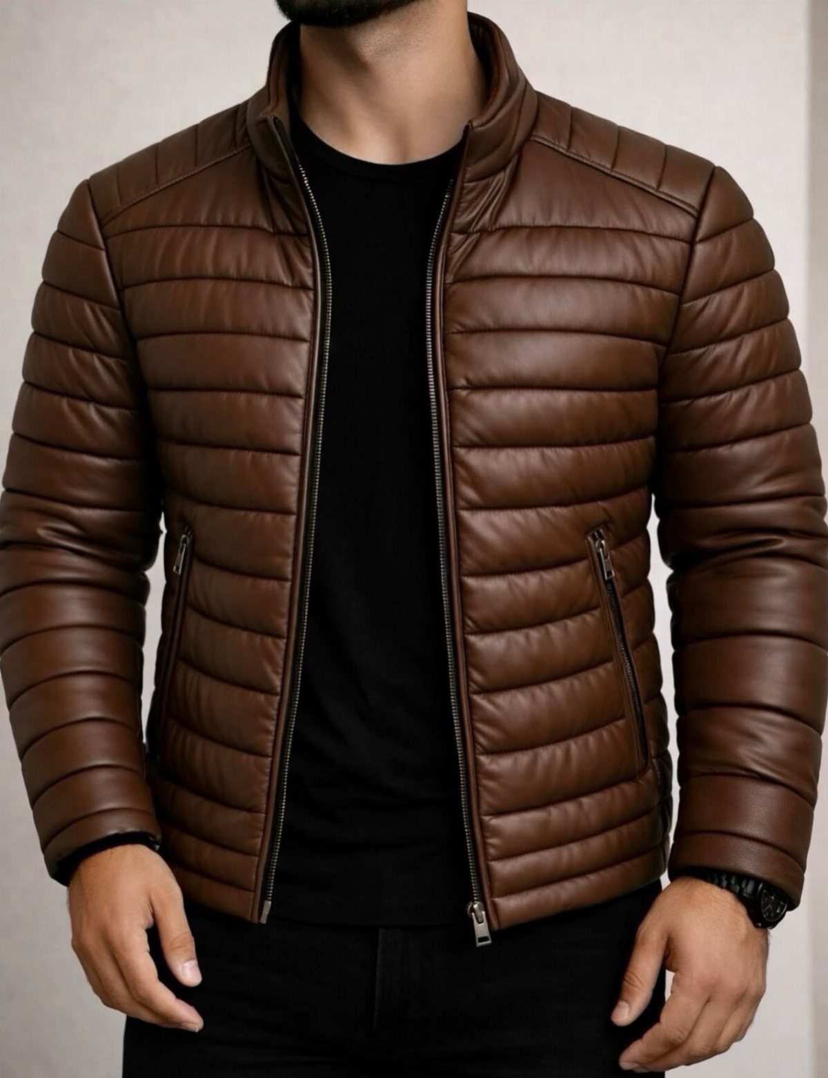 Man wearing a brown quilted leather jacket over a black t-shirt and black pants.